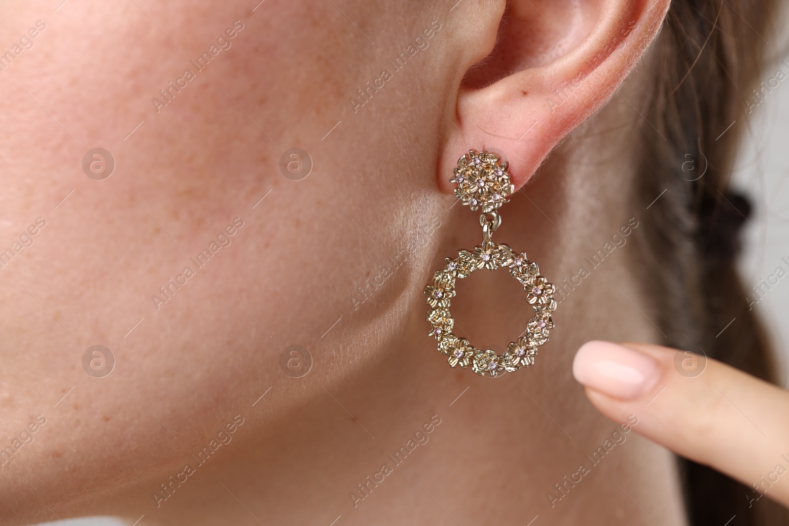 Photo of Woman pointing at her stylish earring, closeup