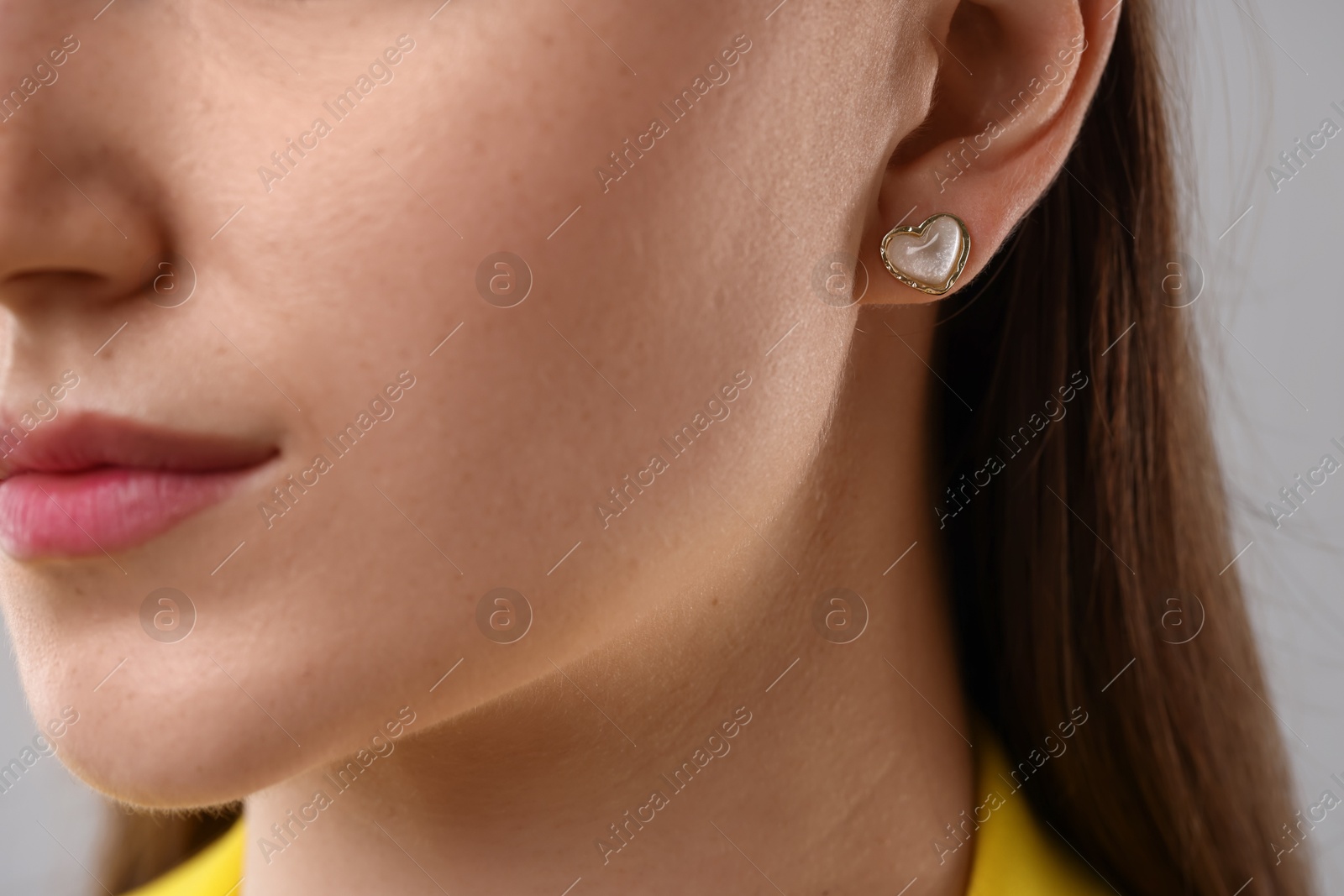Photo of Woman wearing stylish earring on grey background, closeup