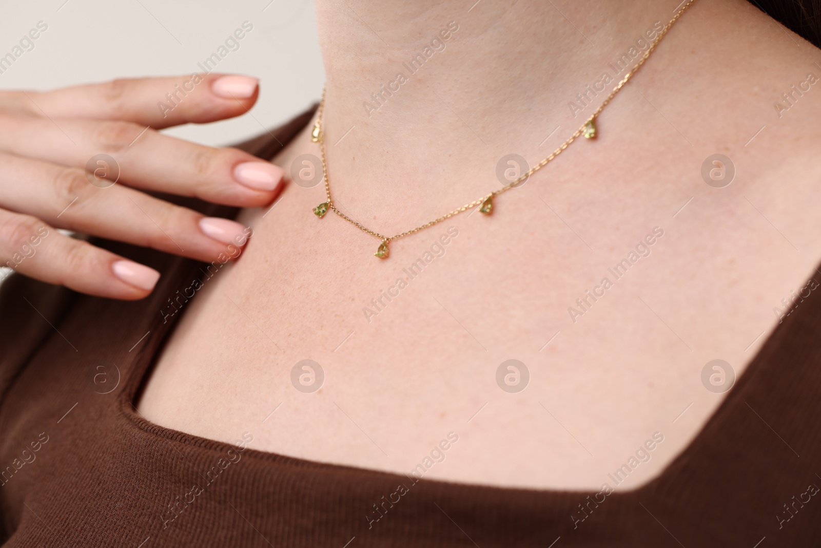 Photo of Woman wearing stylish necklace on light grey background, closeup