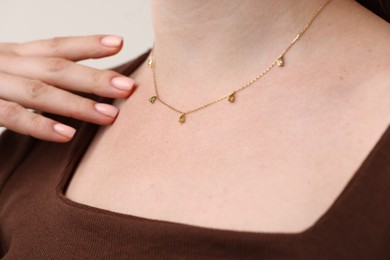 Photo of Woman wearing stylish necklace on light grey background, closeup