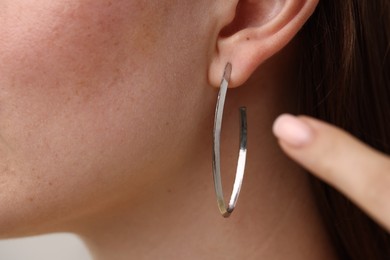 Photo of Woman pointing at her stylish earring, closeup