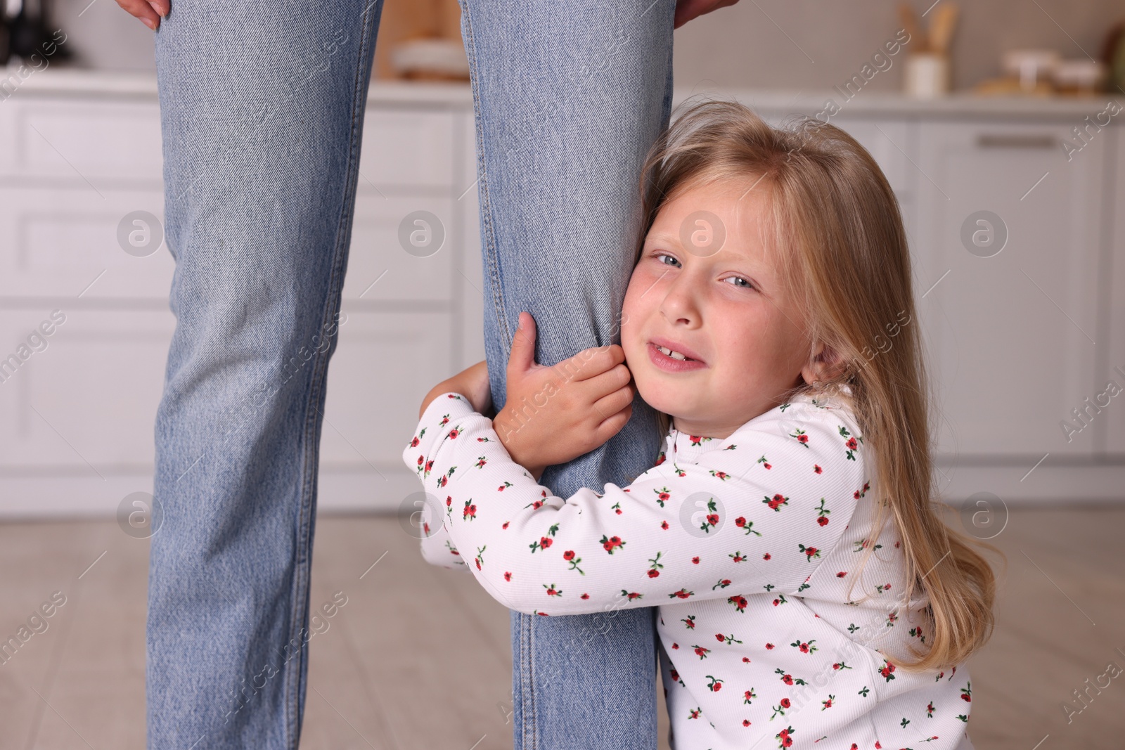 Photo of Little girl afraid to leave without mother and hugging her at home. Separation anxiety