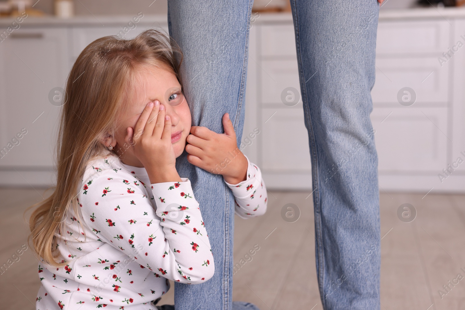 Photo of Little girl afraid to leave without mother and hugging her at home. Separation anxiety