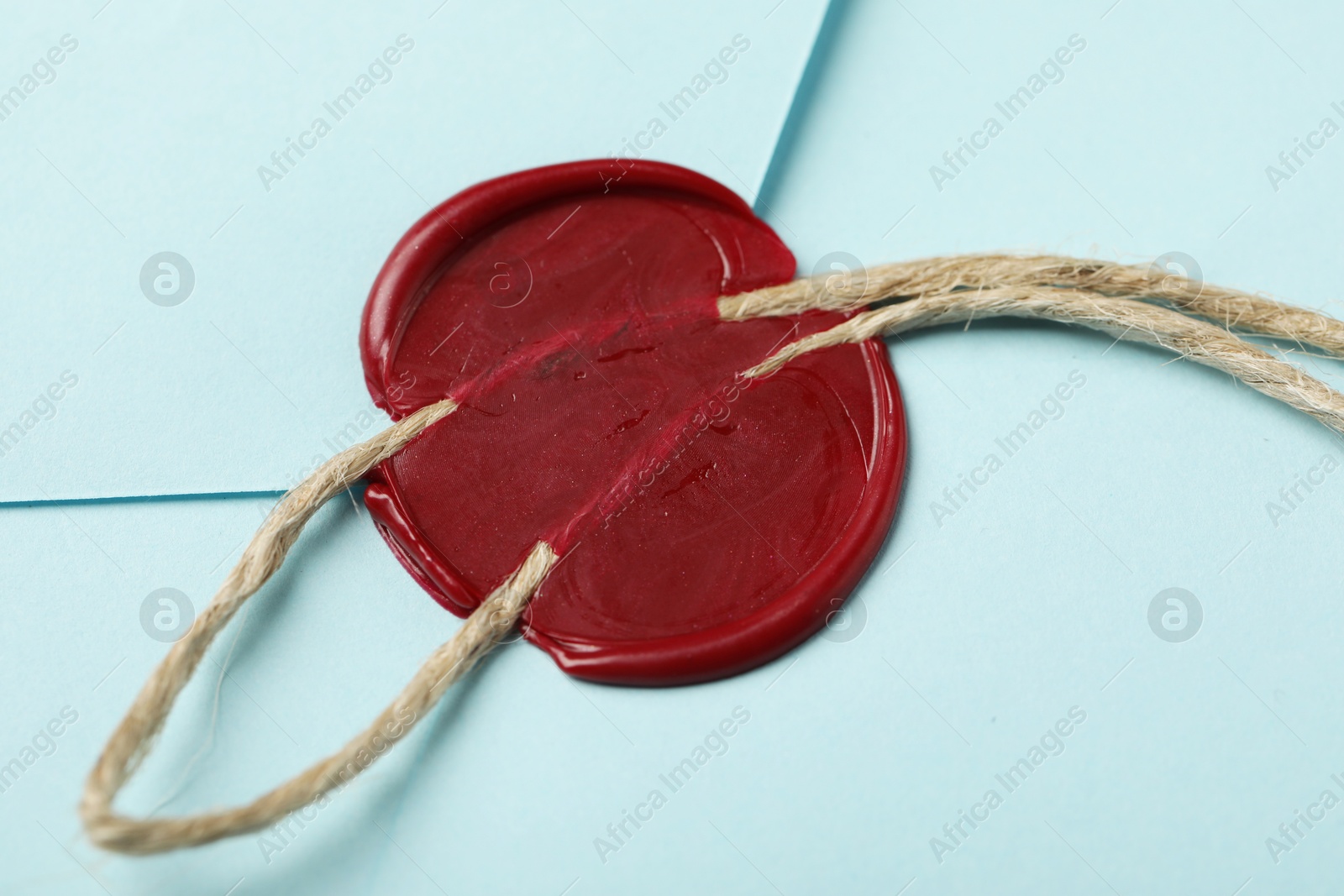 Beautiful envelope with red wax seal and twin as background, closeup Photo of Beautiful envelope with red wax seal and twin as background, closeup