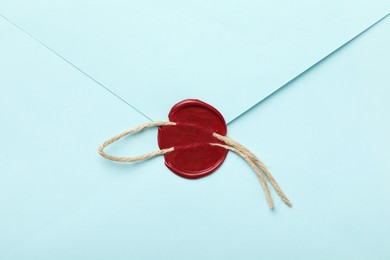 Photo of Beautiful envelope with red wax seal and twin as background, top view