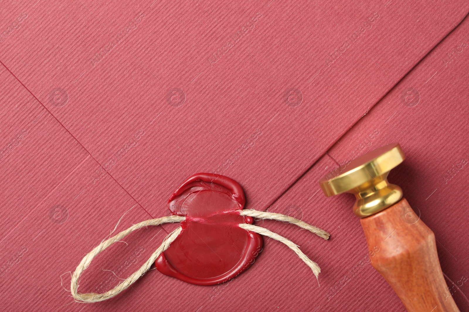 Beautiful envelope with red wax seal, twine and stamp, top view Photo of Beautiful envelope with red wax seal, twine and stamp, top view
