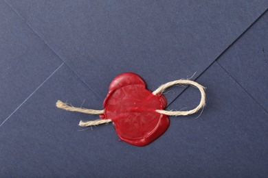 Photo of Beautiful envelope with red wax seal and twin as background, top view