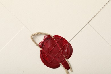 Photo of Beautiful envelope with red wax seal and twin as background, top view