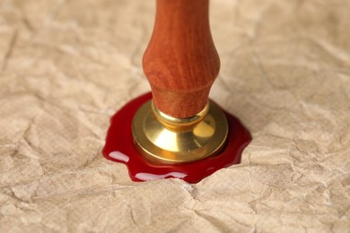 Photo of Sealing crumpled paper with wax stamp, closeup