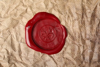 Photo of Red wax seal on crumpled paper, top view
