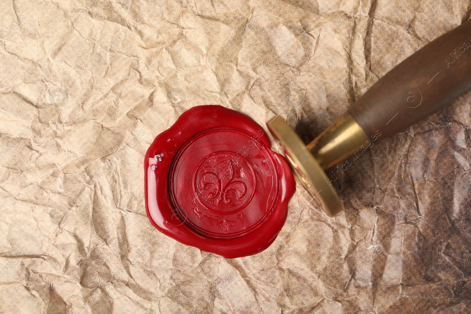 Beautiful wax stamp and red seal on crumpled paper, top view Photo of Beautiful wax stamp and red seal on crumpled paper, top view