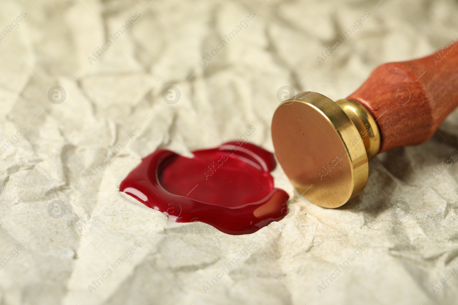 Beautiful wax stamp and red seal on crumpled paper, closeup Photo of Beautiful wax stamp and red seal on crumpled paper, closeup