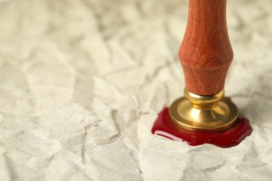 Photo of Sealing crumpled paper with wax stamp, closeup. Space for text