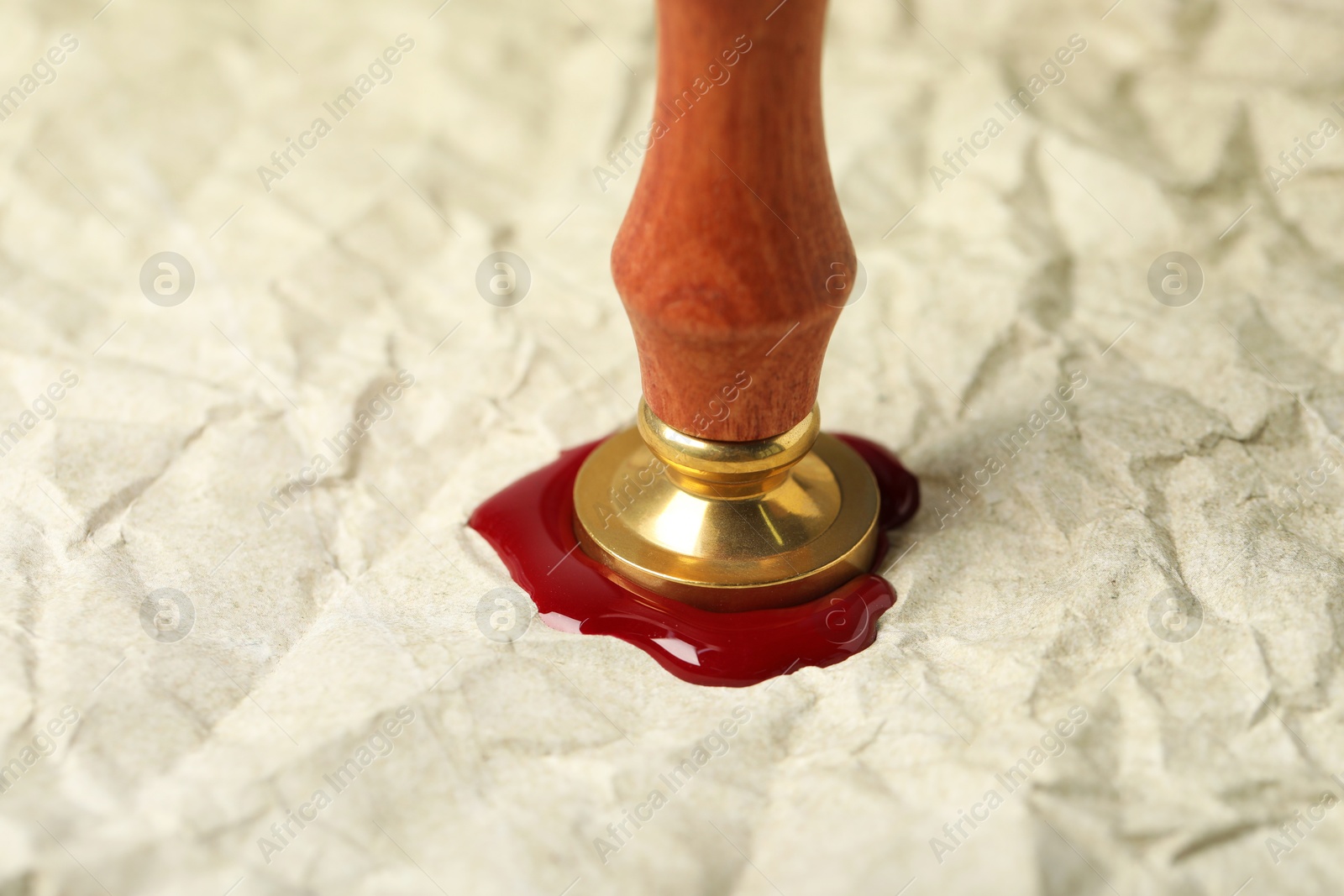 Sealing crumpled paper with wax stamp, closeup Photo of Sealing crumpled paper with wax stamp, closeup