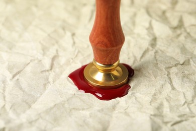 Photo of Sealing crumpled paper with wax stamp, closeup