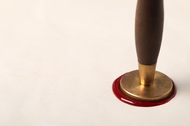 Photo of Sealing white paper with wax stamp, closeup. Space for text