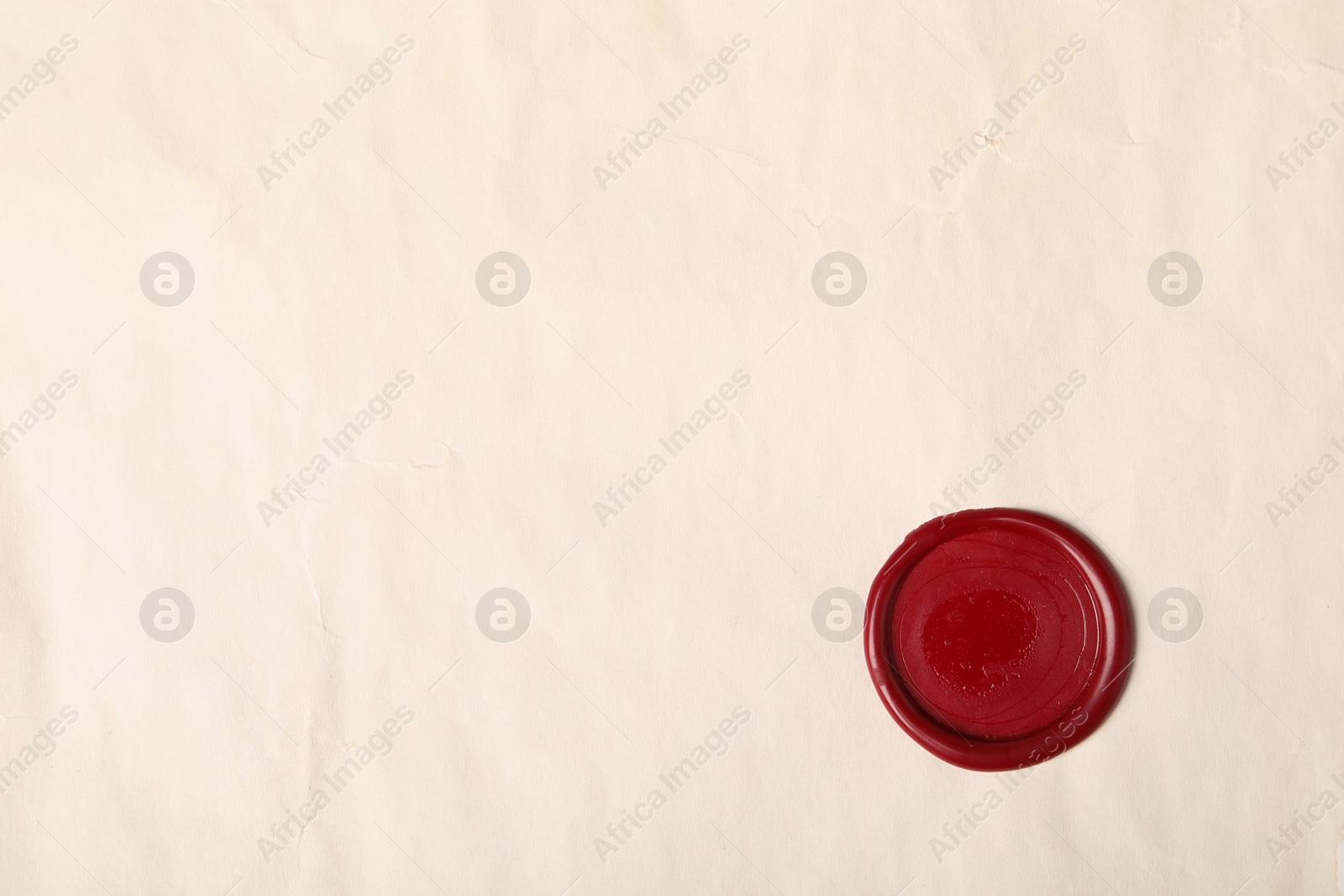 Red wax seal on light paper, top view. Space for text Photo of Red wax seal on light paper, top view. Space for text