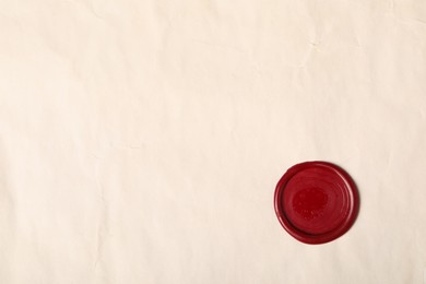 Photo of Red wax seal on light paper, top view. Space for text