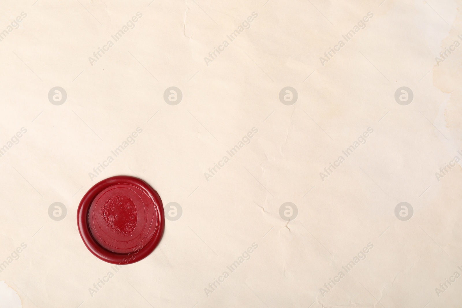 Red wax seal on light paper, top view. Space for text Photo of Red wax seal on light paper, top view. Space for text