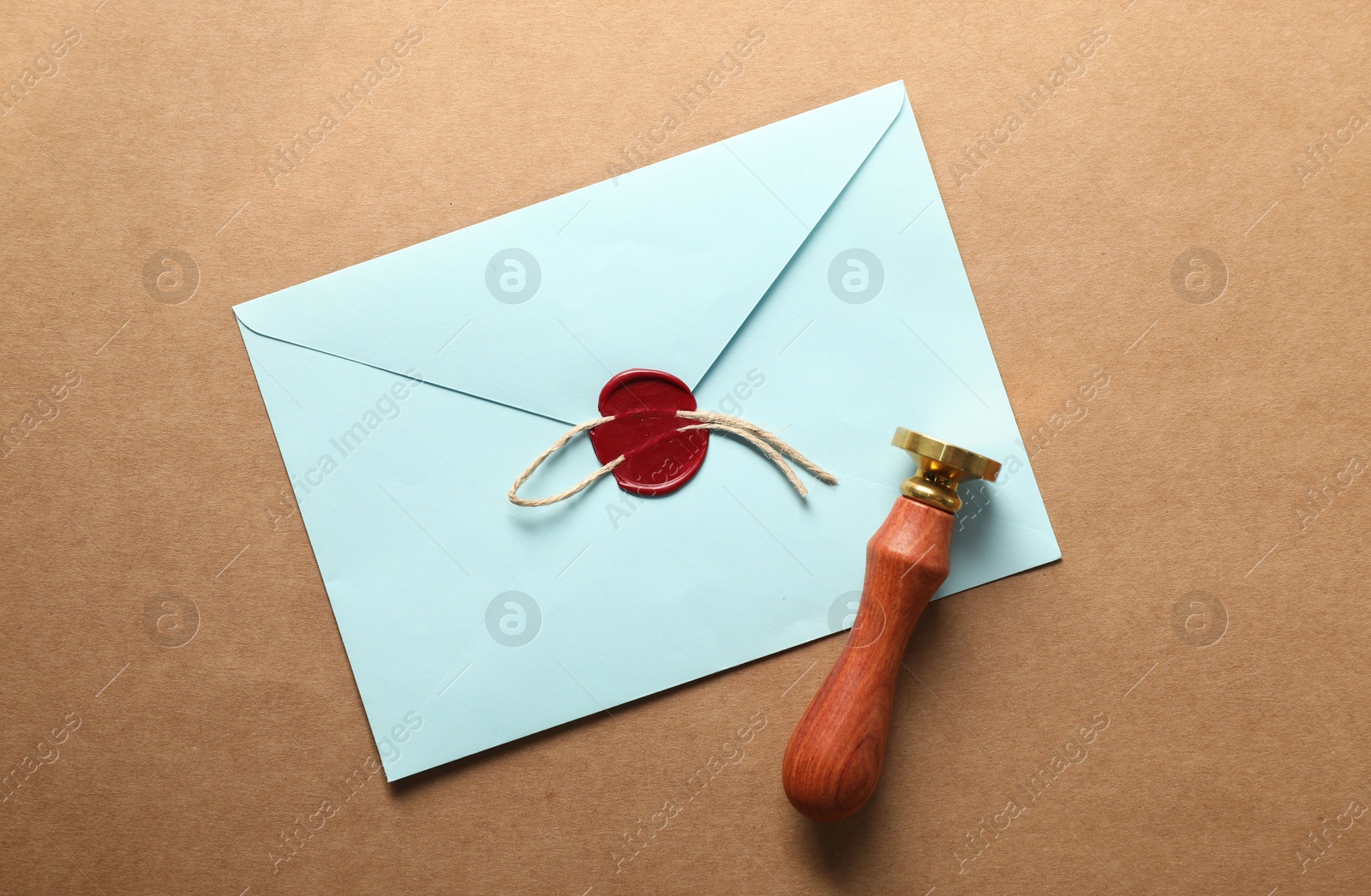 Beautiful wax stamp, envelope with red seal and twine on beige background, top view Photo of Beautiful wax stamp, envelope with red seal and twine on beige background, top view