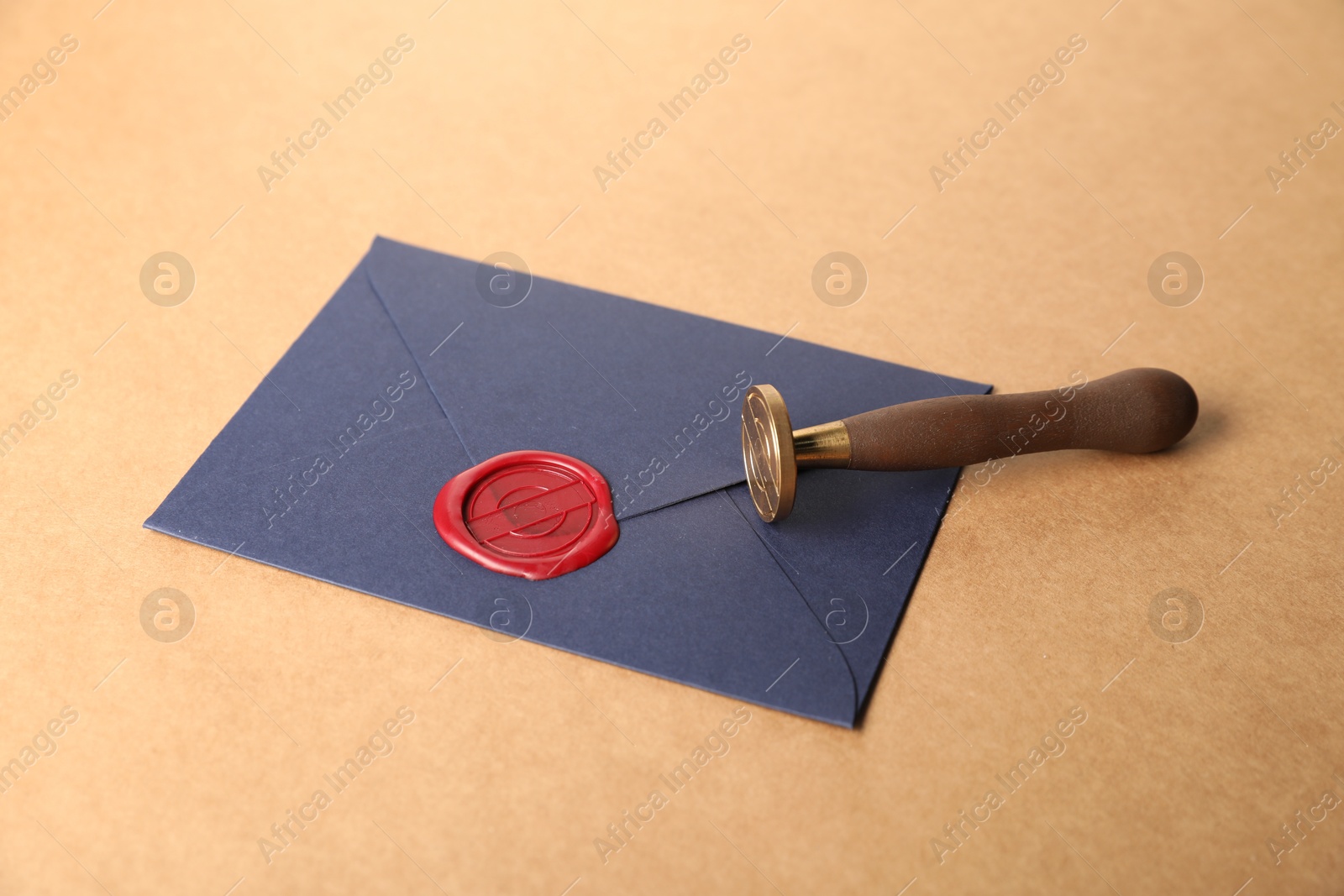 Beautiful wax stamp, envelope with red seal and twine on beige background, closeup Photo of Beautiful wax stamp, envelope with red seal and twine on beige background, closeup