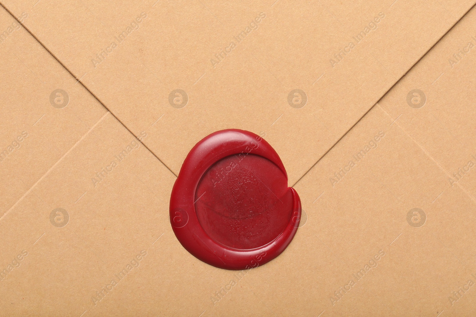 Beautiful envelope with red wax seal as background, top view Photo of Beautiful envelope with red wax seal as background, top view