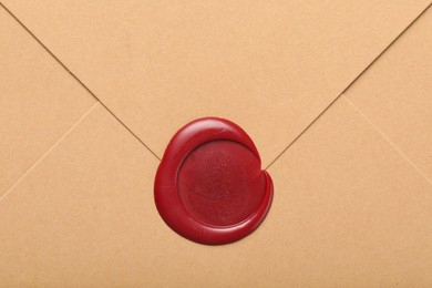 Photo of Beautiful envelope with red wax seal as background, top view