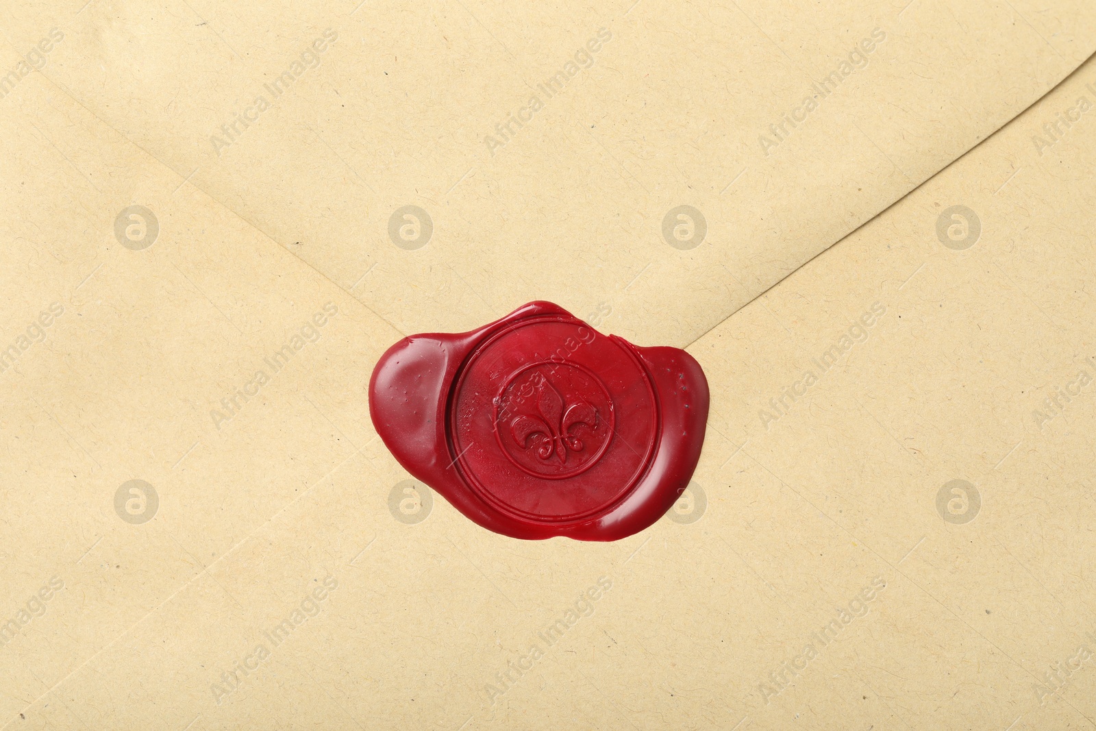 Beautiful envelope with red wax seal as background, top view Photo of Beautiful envelope with red wax seal as background, top view