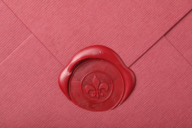 Photo of Beautiful envelope with red wax seal as background, top view