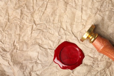 Photo of Beautiful wax stamp and red seal on crumpled paper, top view. Space for text