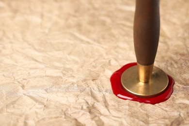 Photo of Sealing crumpled paper with wax stamp, closeup. Space for text