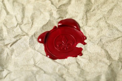 Photo of Red wax seal on crumpled paper, closeup