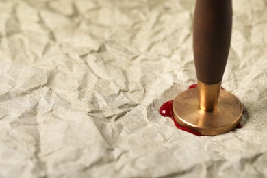 Photo of Sealing crumpled paper with wax stamp, closeup. Space for text