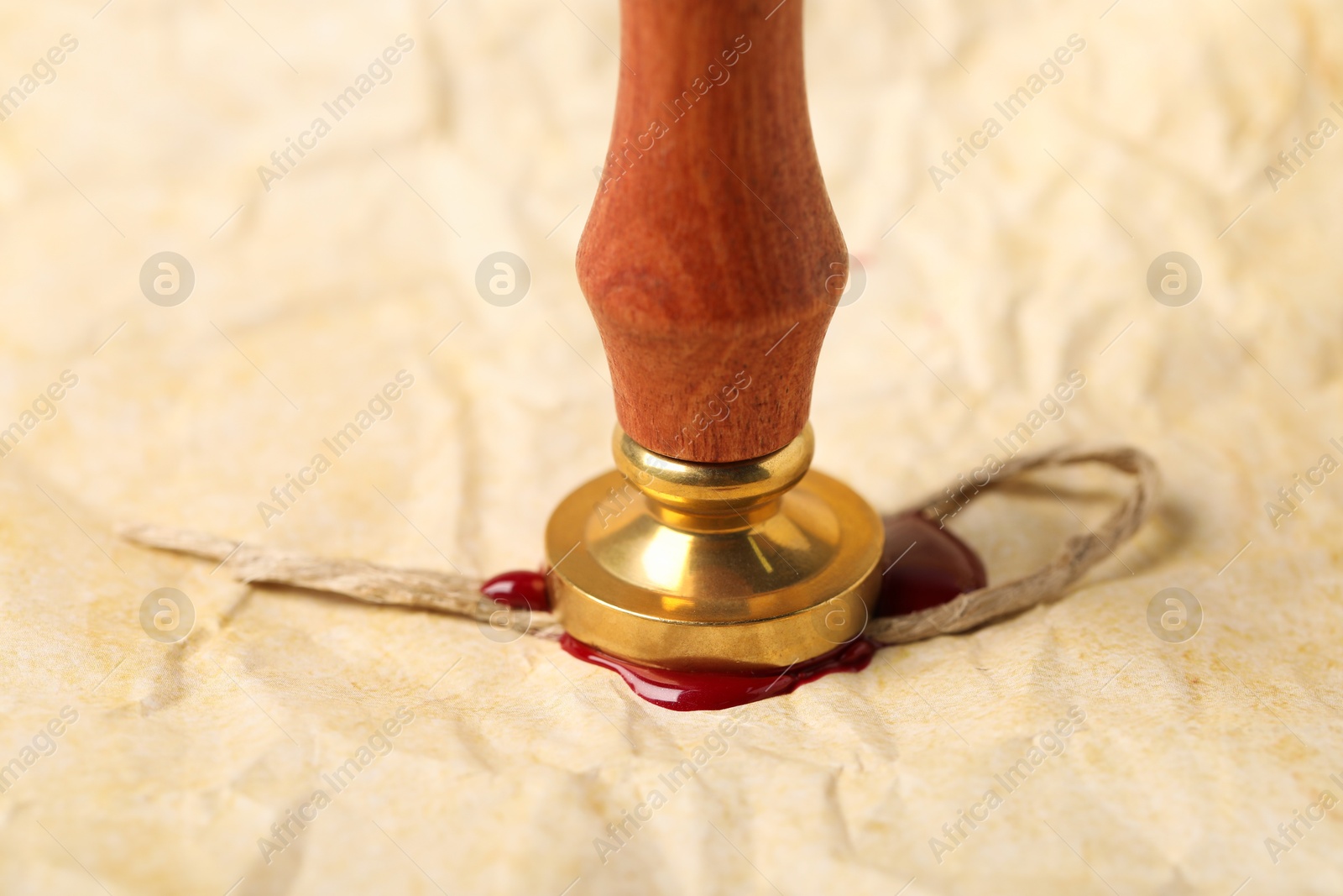 Sealing crumpled paper with wax stamp, closeup Photo of Sealing crumpled paper with wax stamp, closeup