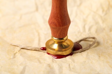 Photo of Sealing crumpled paper with wax stamp, closeup