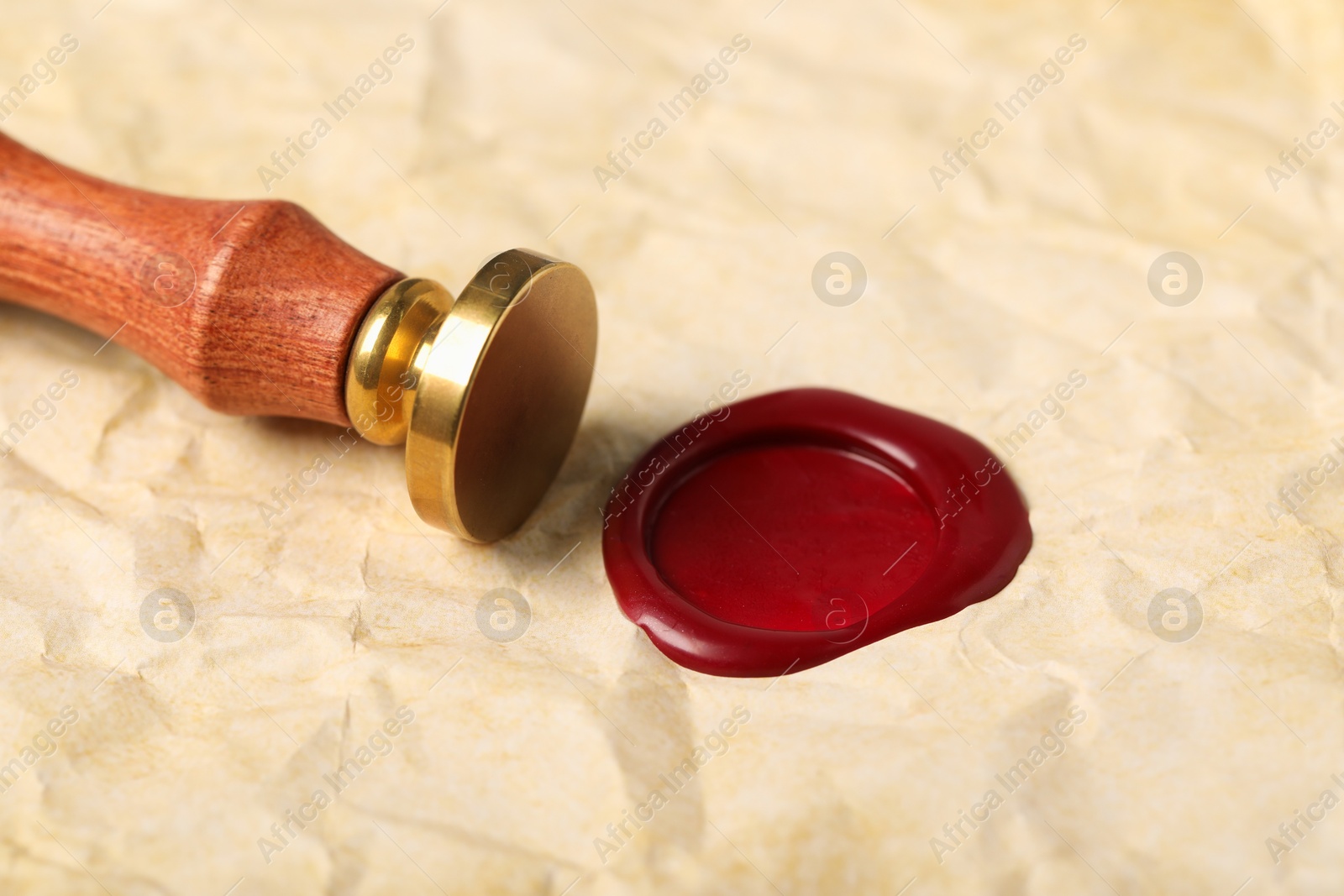 Beautiful wax stamp and red seal on crumpled paper, closeup Photo of Beautiful wax stamp and red seal on crumpled paper, closeup