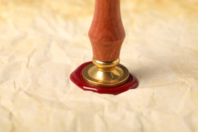 Photo of Sealing crumpled paper with wax stamp, closeup