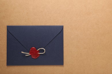 Photo of Beautiful envelope with red wax seal and twine on beige background, top view. Space for text