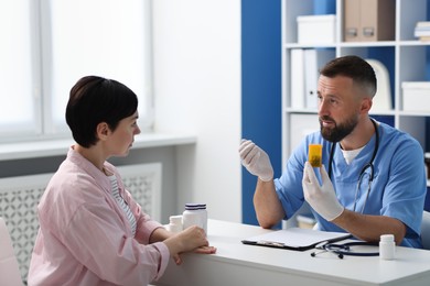 Photo of Gastroenterologist recommending pills to woman in clinic