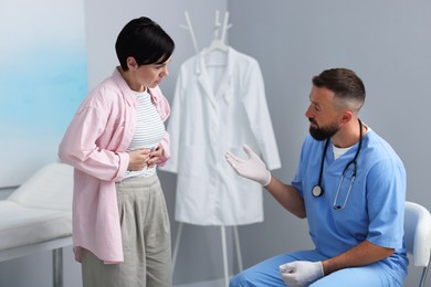 Photo of Gastroenterologist consulting patient with stomach pain in clinic