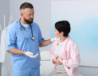 Photo of Gastroenterologist consulting patient with stomach pain in clinic