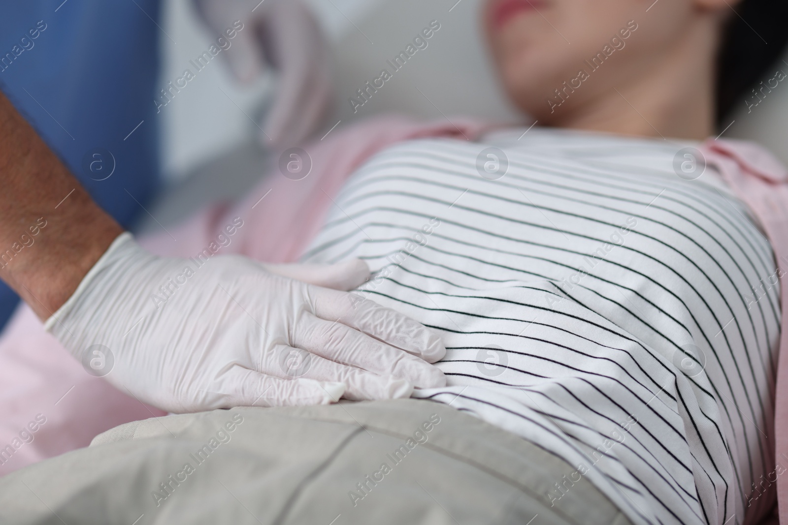 Photo of Gastroenterologist examining patient's stomach in clinic, closeup