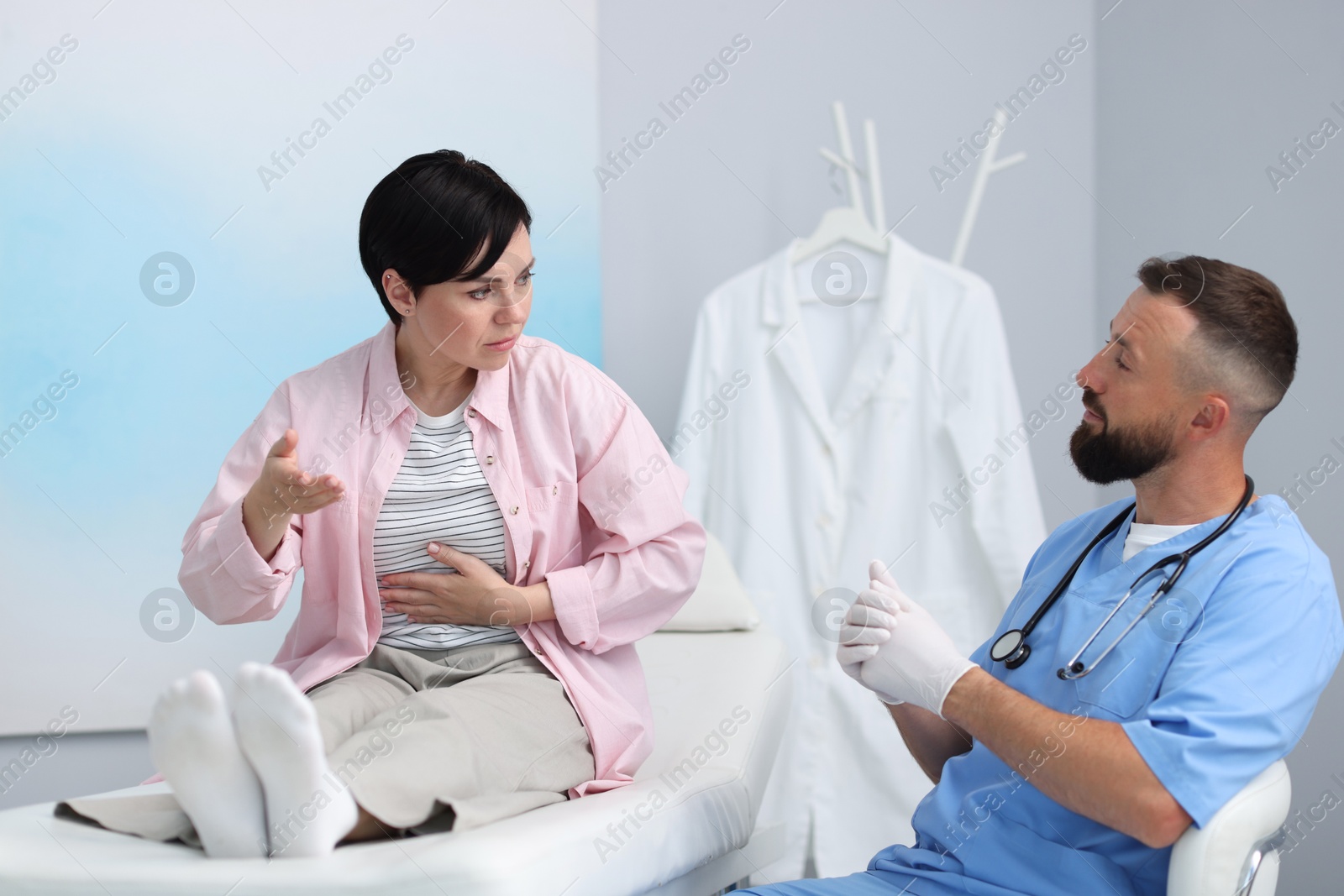 Photo of Gastroenterologist consulting patient with stomach pain in clinic