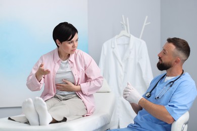 Photo of Gastroenterologist consulting patient with stomach pain in clinic