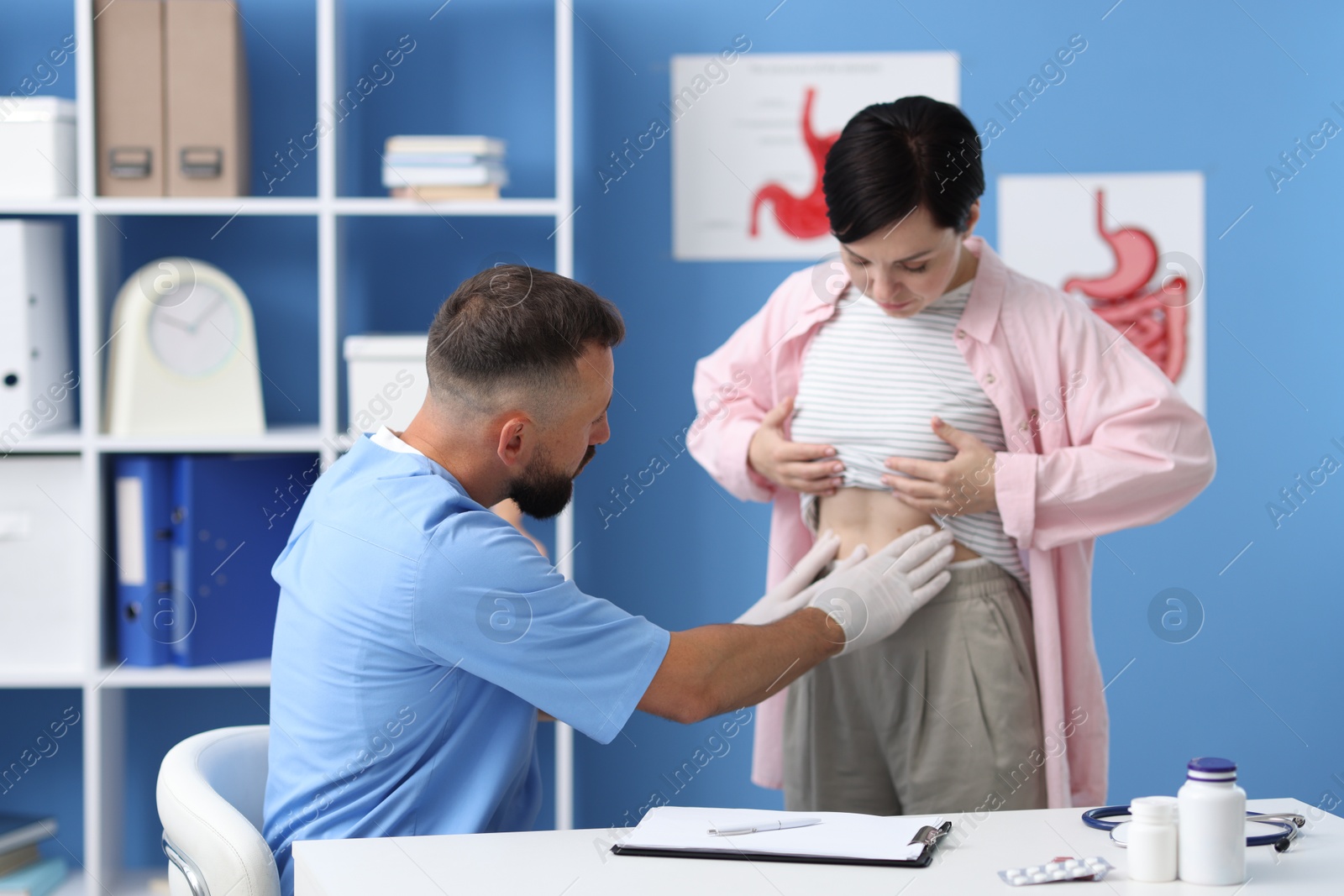 Photo of Gastroenterologist examining patient with stomach pain in clinic