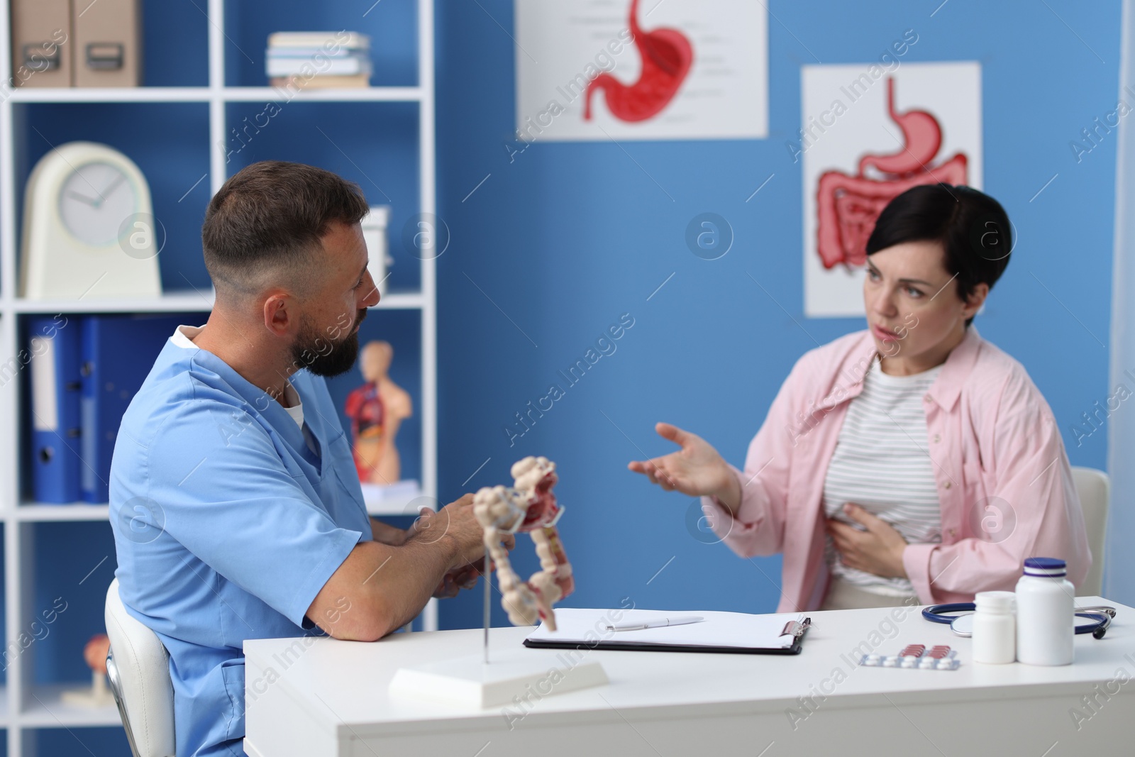 Photo of Gastroenterologist consulting patient with stomach pain in clinic