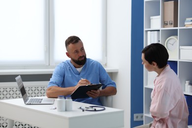 Photo of Gastroenterologist consulting patient with stomach pain in clinic