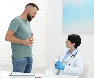 Photo of Gastroenterologist consulting patient with stomach pain in clinic