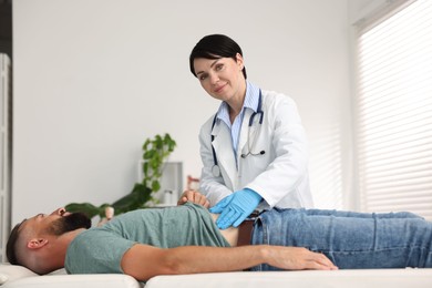 Photo of Gastroenterologist examining patient with stomach pain in clinic