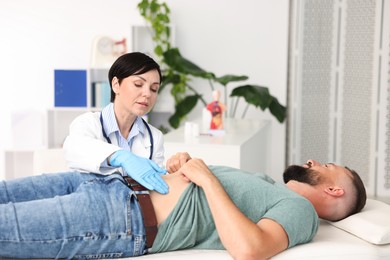 Photo of Gastroenterologist examining patient with stomach pain in clinic